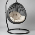 Charcoal grey woven rattan hanging egg chair with black steel stand and beige cushions