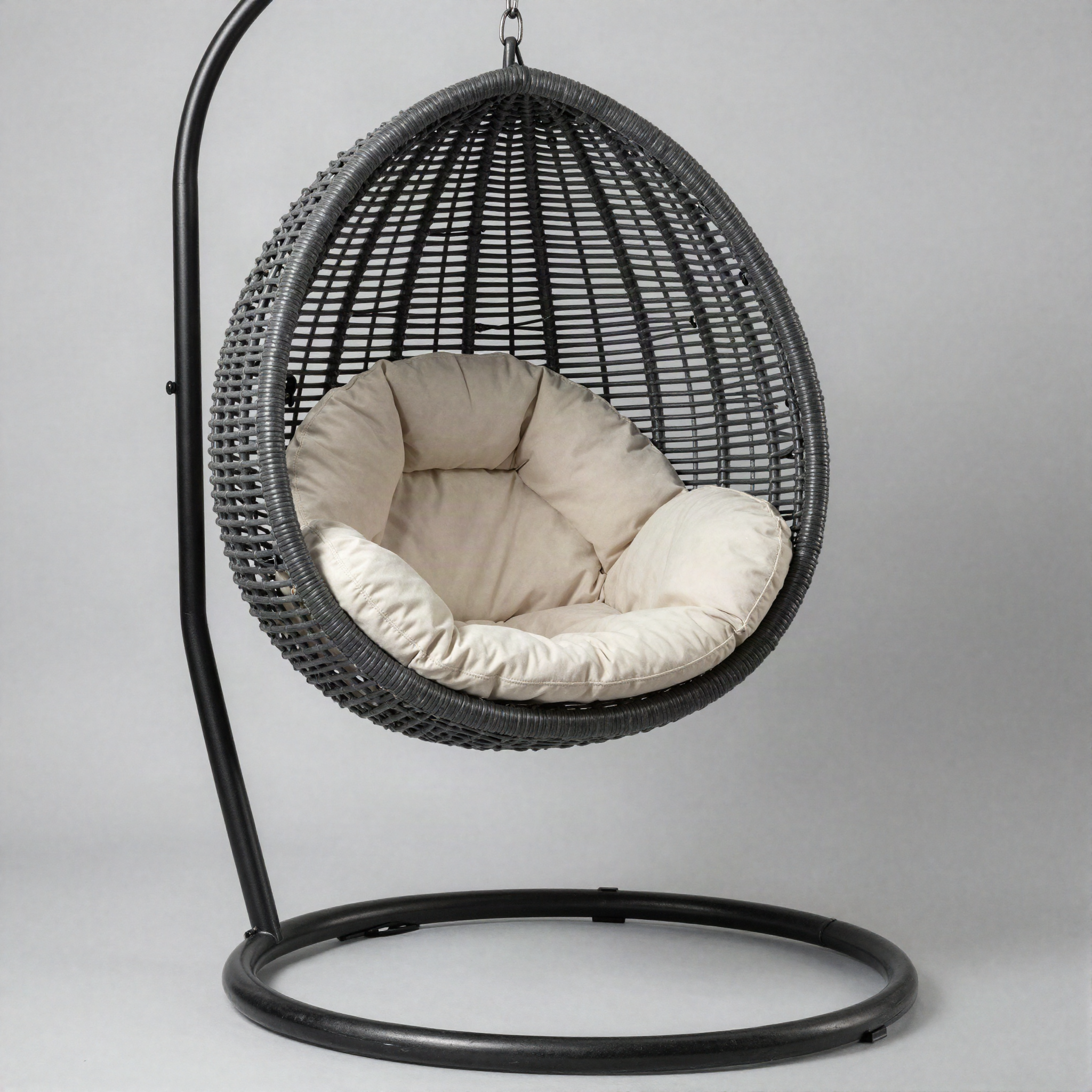 Charcoal grey woven rattan hanging egg chair with black steel stand and beige cushions