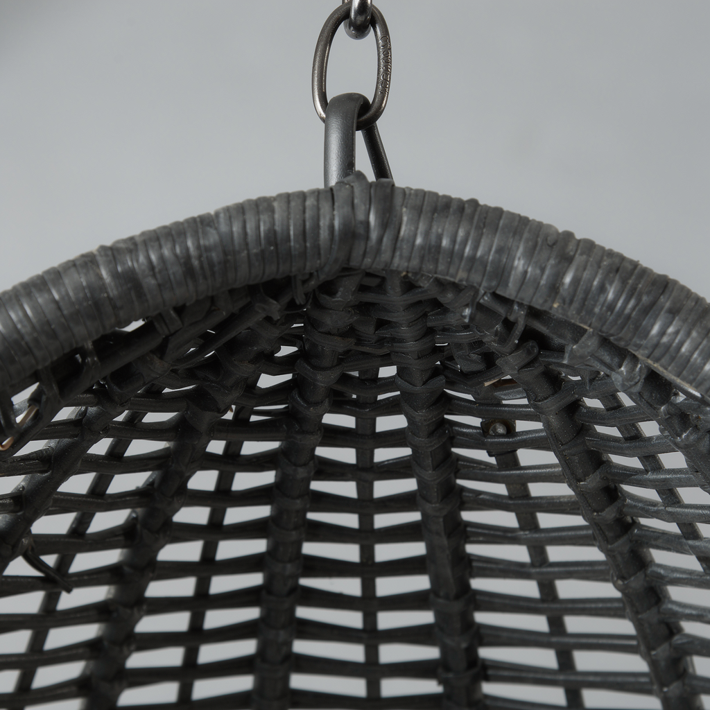 Macro of the egg chair's woven PE rattan texture and suspension chain